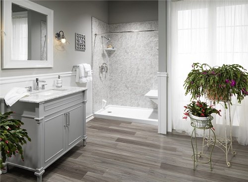 A modern bathroom with gray hardwood floors, a walk-in shower, and gray vanity.