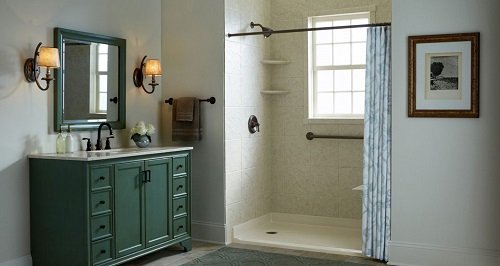 A bathroom with a green vanity and low-threshold shower. 
